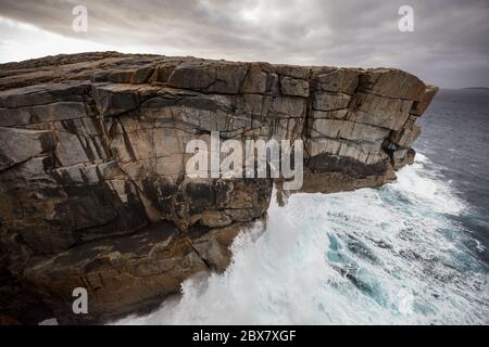 Dramatic early morning light and crashing waves at the Gap rock formation in Torndirrup National Park, Albany, Western Australia Stock Photo
