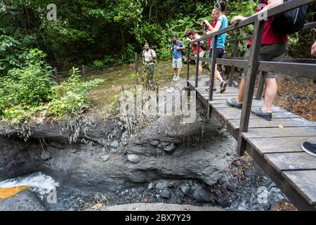 Alan, tour guide with Swiss Travel communicates with hikers standing on a bridge observing ash from recent eruption of Rincón de la Vieja Volcano, Cos Stock Photo