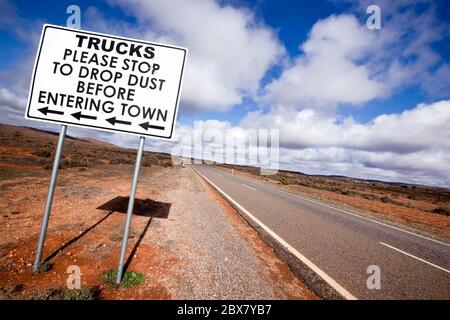 Road sign in the Australian outback, asking trucks to stop to drop dust before entering town.  Outside Broken Hill, in western New South Wales. Stock Photo