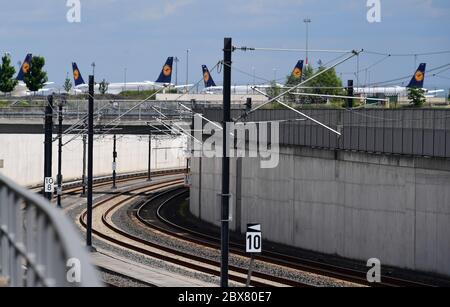 Potsdam, Germany. 02nd June, 2020. The rails of the S-Bahn (l) and the regional railway lead into a tunnel to the underground station of the capital airport. In the background, off the tarmac, there are aircraft of the airline Lufthansa. Credit: Soeren Stache/dpa-Zentralbild/ZB/dpa/Alamy Live News Stock Photo