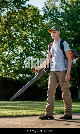 Caucasian man using backpack leaf blower in Kentucky Stock Photo