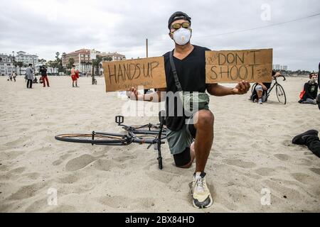 Santa Monica, United States. 05th June, 2020. A protester holds two placards to raise awareness of the death of George Floyd. Protesters marched from the Venice Beach Pier to the Santa Monica Pier to honour George Floyd and to call for reform to end police brutality. Credit: SOPA Images Limited/Alamy Live News Stock Photo