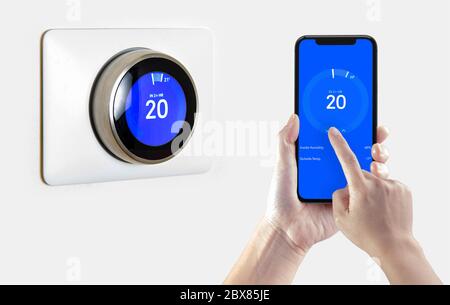 A person using a smart phone application cooling down the room temperature with a wireless smart thermostat on a white background. Stock Photo