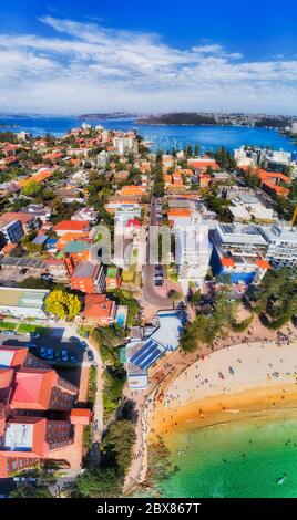 Great local sandy beach in Manly suburb of Sydney on Pacific ocean cost - vertical aerial panorama with view of distant Sydney harbour and city CBD. Stock Photo