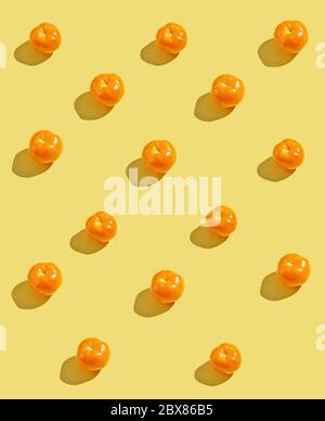 yellow tomatoes with long shadows isolated on yellow background Stock Photo
