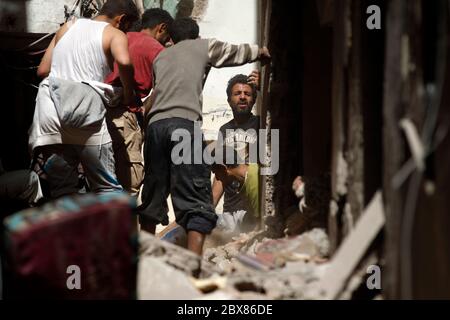 Yemenis sift the rubble of a heavily damaged building following reported Saudi-led coalition air strikes in the Yemeni capital Sanaa on May 16, 2019. Stock Photo