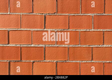 Closeup of a brick wall under the sunlight. Abstract red brown background Stock Photo