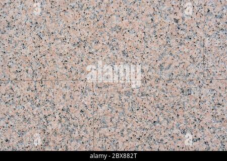 Closeup of granite tile on the wall. Stone beige spotted abstract background. Material for design and decoration of the exterior Stock Photo