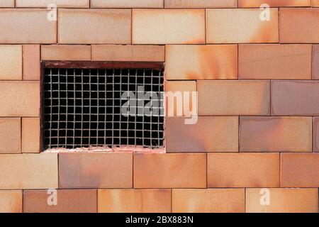 Old basement window with a rusty old prison iron grate with cobwebs on a brickwork wall. Copyspace. Concept of imprisonment Stock Photo