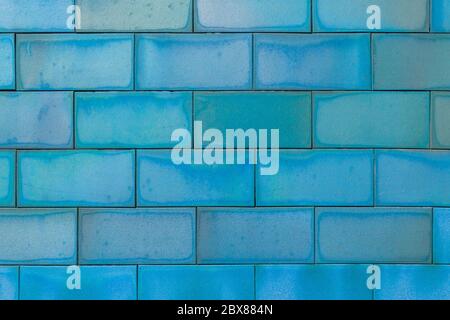 Brick tiled blue old wall made of symmetrical blocks. Abstract colorful background Stock Photo