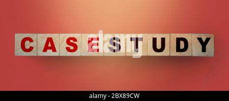 Case Study written on a wooden cube in a soft red gradient background. Examples concept Stock Photo