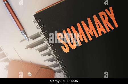Word SUMMARY, on copybook cover, financial report, pen and wallet. Business brief review and conclusions concept Stock Photo