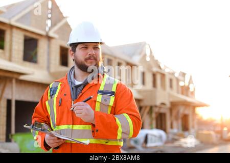 Foreman writing in notebook on construction site. Stock Photo