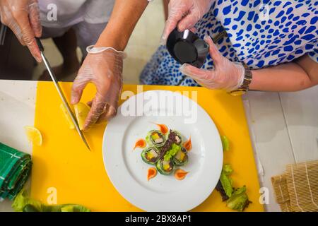 happy Asian couple cooking together -  home kitchen lifestyle portrait of Chinese cheerful and sweet husband and wife making delicious traditional Jap Stock Photo