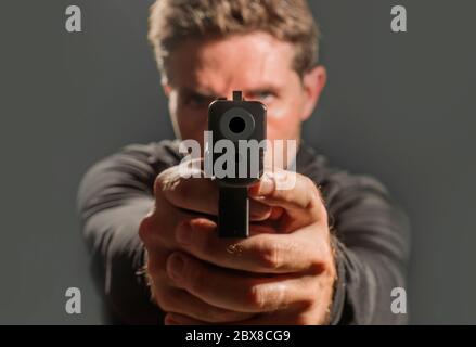 guy pointing gun at camera stock photo