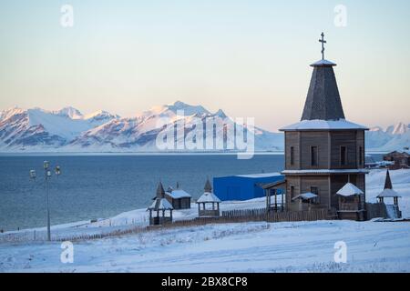 Russian church with snow covered landscape in an old mining town called 'Barentsburg' on Spitsbergen. Stock Photo