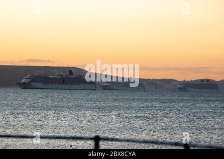 Weymouth, UK. 6th June, 2020. The early morning sunrise over the cruise ships ARCADIA, AURORA, and BRITANNIA in Weymouth Bay. Stock Photo