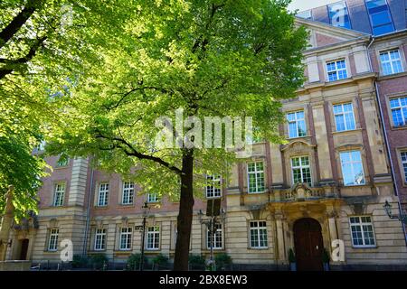 Typical romantic backstreet in Düsseldorf Old Town with ancient brick stone building and old tree in front. Stock Photo