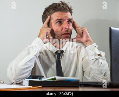 corporate business work stress - young desperate and frustrated businessman working stressed and overwhelmed at office computer desk sad feeling depre Stock Photo
