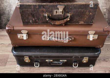 Old Vintage Suitcase in retro room on the floor, three piled suitcases background Stock Photo