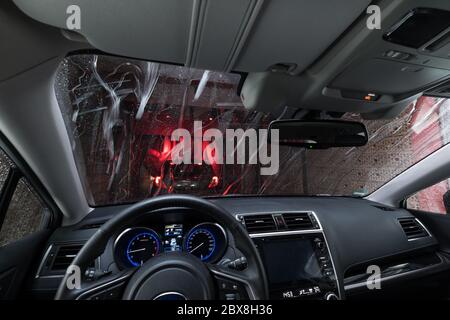 Automatic car wash with conveyor belt. A view through the windshield from the car that is pulled to the drying tunnel Stock Photo