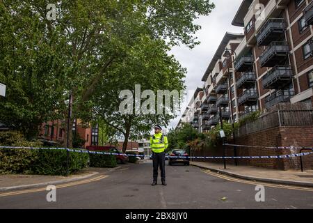 Police at the scene on Brackenfield Close in Hackney, east London, where a man in his 20s died following a suspected shooting on Friday evening. Stock Photo