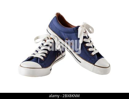 Pair of classic blue sneakers or gumshoes with white shoe laces isolated on white background. Comfortable shoes for fitness and sport. Front view. Stock Photo