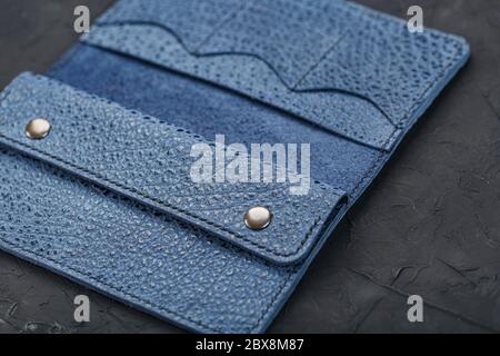 Blue leather wallet on a black textured background. Stock Photo