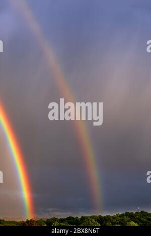 Rainbows over suburban housing Stock Photo