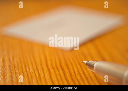 Ball pen and white paper on the wooden table. Macro photo. Copy space. Stock Photo
