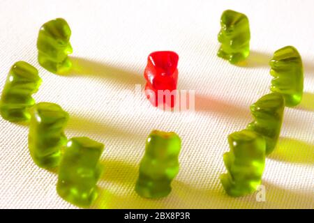 sweet candy gummy teddy bears representing group of students or work colleagues bullying and mobbing helpless victim in harassment and abuse social pr Stock Photo