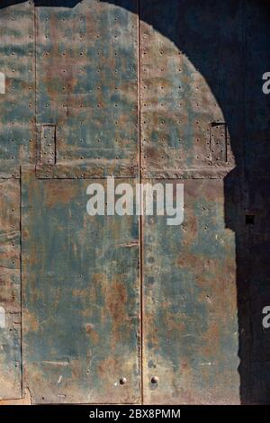 Closeup of an ancient wrought iron door with studs and rust. Full frame, background. Trento, Trentino Alto Adige, Italy, Europe Stock Photo