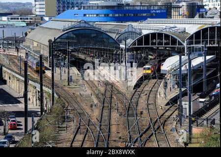 Elevated view of Newcastle Central Station; trains at platforms; tracks and overhead electric cables in foreground; NHS Centre for Life in background. Stock Photo