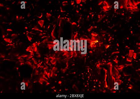 Actively smoldering embers of fire. Background of burning hot coals. Flicker of burning coals at night. Closeup of burning charcoal Stock Photo