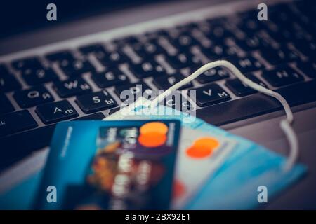 Work from home concept due to Covid-19 or Coronavirus with laptop medical mask and credit cards. Selective focus image. Stock Photo