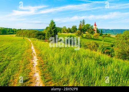 Small church in the middle of lush green spring landscape on sunny day. St. Peter and Pauls church at Bysicky near Lazne Belohrad, Czech Republic. Stock Photo
