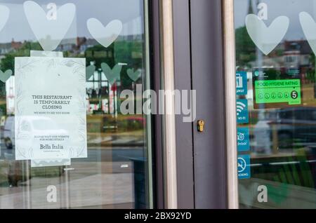 New Brighton, UK: Jun 3, 2020: A poster displayed in the window of a Bella Italia restaurant states that the business is closed. This is due to the co Stock Photo