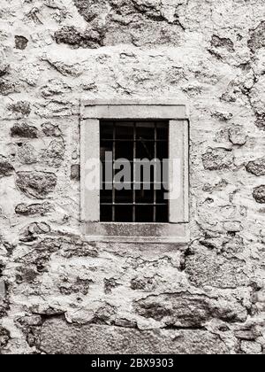 Old prison jail window with rusty metal bars. Vintage style image. Stock Photo