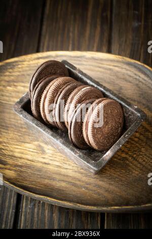 Dark cookie of two chocolate wafers with a sweet creme filling in between, vertical image Stock Photo