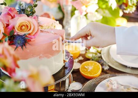 wedding decor on a table with cake, candles and fruits Stock Photo