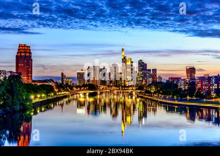 Beautiful view on  Frankfurt am Main downtown skyline cityscape, bridge with lights during twilight blue hour sunset, evening, night. European finance