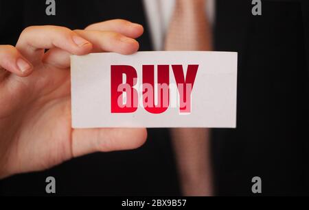 Buy word on the card shown by a businessman. Shopping spending concept Stock Photo