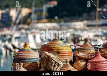Closeup of multicolored African baskets made and woven with dried seaweeds, for sale on a waterfront in Liguria, Italy, Europe Stock Photo