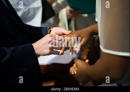 White skin man and black skin woman are getting married in a church Stock Photo