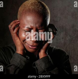 young stylish sad and depressed afro american black woman crying in despair holding head with hands feeling miserable and desperate suffering depressi Stock Photo