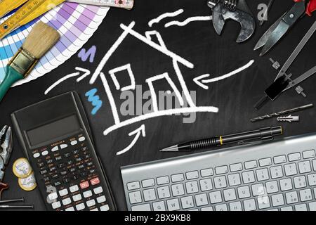 Home improvement concept - Black chalkboard with a chalk drawing of a house, work tools, calculator, computer keyboard and euro currency