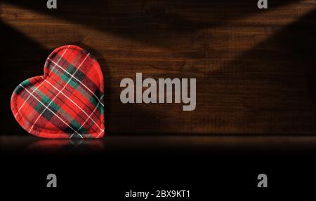 Fabric heart shape on a dark wooden background with reflection and copy space Stock Photo