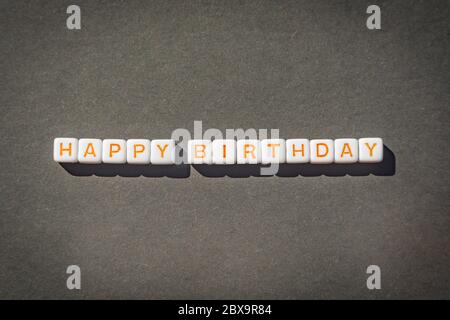 Happy Birthday postcard with orange letters on grey background Stock Photo