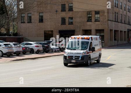 Saint John, New Brunswick, Canada - April 5, 2018: An ambulance travels at high speed down a road. The red lights are illuminated. Stock Photo
