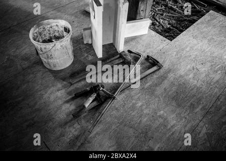 on a building site two steel clamps, a big hammer and a bucket lie side by side Stock Photo